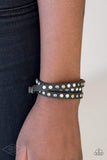 A skinny strip of black leather is encrusted in sections of glittery white rhinestones and flat brass, gold, and silver studs. The elongated band double wraps around the wrist for a fierce one-of-a-kind look. Features an adjustable snap closure. Sold as one individual bracelet.  P9DI-URBK-134XX