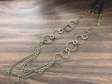 Smooth and shimmery textured hoops give way to layers of mismatched brass chains for a classic look. Features an adjustable clasp closure. Sold as one individual necklace. Includes one pair of matching earrings.  P2IN-BSXX-179XX