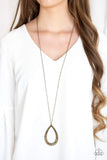 An oversized brass teardrop frame is encrusted in glittery aurum rhinestones that gradually increase in size at the bottom for a show stopping finish. The sparkling pendant swings from the bottom of a lengthened brass chain for a slimming finish. Features an adjustable clasp closure. Sold as one individual necklace. Includes one pair of matching earrings. P2ED-BRXX-104XX