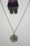 A dainty tree charm attaches to a shimmery brass chain, creating a whimsical pendant for a seasonal look. Features an adjustable clasp closure. Sold as one individual necklace. Includes one pair of matching earrings.  P2DA-BRXX-109XX