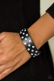 Encased in shimmery silver frames, glittery white rhinestones are sprinkled along a shiny black leather band for a dramatic look. Features an adjustable snap closure. Sold as one individual bracelet.  P9DI-URBK-124XX