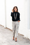 Attached to two strips of black leather, strands of bedazzled white rhinestone encrusted silver beads drape between an exaggerated display of mismatched silver and gunmetal chains down the chest. With its edgy sparkle, grunge meets glamour in this heart-stopping statement-maker. Features an adjustable clasp closure. Sold as one individual necklace. Includes one pair of matching earrings.  Named after 2020 Rock the Runway winner, Arlingto L.  Z2009