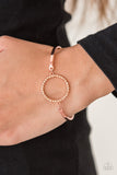 Encrusted in glittery peach rhinestones, a circular frame attaches to two shiny copper bars, creating a refined centerpiece. Features an adjustable clasp closure. Sold as one individual bracelet.  P9RE-CPSH-087XX