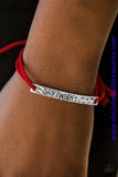 Fiery red strands of suede loop through a delicately hammered plate. The shimmery frame is stamped in the word, “Wish” for a whimsical look. Features an adjustable sliding knot closure. P9WD-RDXX-046XX