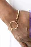 Encrusted in glittery white rhinestones, a circular frame attaches to two gold bars, creating a refined centerpiece. Features an adjustable clasp closure. Sold as one individual bracelet.  P9DA-GDXX-135XX