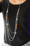Ornate silver accents, glassy beads, and polished orange beads trickle along strands of shimmery silver chains for a whimsical look. Features an adjustable clasp closure. Sold as one individual necklace. Includes one pair of matching earrings.  P2WH-OGXX-188XX