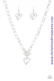 Cut into a whimsical heart shape, a glittery white gem swings from the bottom of a glistening silver chain below the collar for a charming look. Features a toggle closure. Sold as one individual necklace. Includes one pair of matching earrings.  P2WH-WTXX-222XX