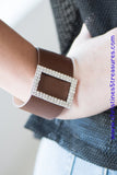 Two rows of dazzling white rhinestones coalesce into a rectangular frame. The glittery frame is threaded along a band of brown leather, creating a stunning centerpiece. Features an adjustable snap closure. Sold as one individual bracelet.  P9DI-URBN-032XX