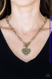 Brushed in an antiqued finish, brass filigree climbs a heart-shaped frame, creating a vintage inspired pendant below the collar. Features a toggle closure. Sold as one individual necklace. Includes one pair of matching earrings.   P2WH-BRXX-136XX