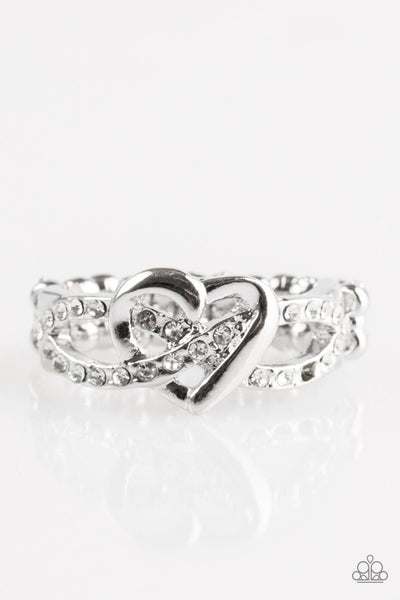 Encrusted in glittery white rhinestones, silver ribbons crisscross across the finger, creating a dainty band. A glistening silver heart adorns the center of the band for a romantic finish. Features a dainty stretchy band for a flexible fit.  P4RE-WTXX-235XX