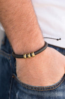 Shiny black twine wraps around a black cord, creating an urban look around the wrist. Shiny brass beads slide along the cording for a rugged finish. Features an adjustable sliding knot closure.  P9UR-BKXX-242PU