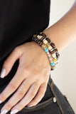 A mismatched collection of brown wooden beads, silver accents, turquoise stones, and glassy yellow beads are threaded along stretchy bands, creating colorful layers around the wrist. Sold as one set of three bracelets.  P9SE-YWXX-136XX