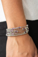 A collection of silver beads, glowing purple cat's eye stones, and studded silver accents are threaded along a coiled wire, creating a colorful infinity wrap style bracelet around the wrist. Sold as one individual bracelet. P9WH-PRXX-211XX