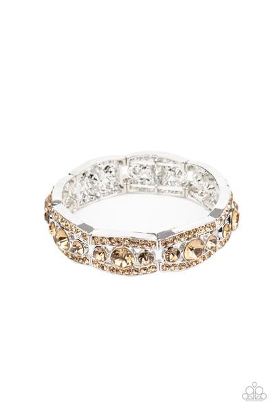 Topaz rhinestone encrusted silver bars flank a dazzling trio of oversized topaz rhinestones, coalescing into a glittery frame. The sparkly frames are threaded along stretchy bands around the wrist, creating an irresistible shimmer. Sold as one individual bracelet.  P9RE-BNXX-145XX