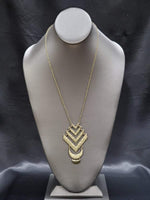 2020 February Fashion Fix Exclusive Featuring an antiqued finish, hammered chevron-like and crescent shaped frames link at the bottom of a lengthened brass chain, creating a stacked tribal inspired pendant. Features an adjustable clasp closure. Sold as one individual necklace. Includes one pair of matching earrings. P2TR-BRXX-100SM