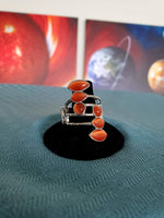 2019 December Fashion Fix Exclusive Featuring round, teardrop, and marquise shapes, two frames of glowing orange cat's eye stones stack across a layered silver band for an all around radiance. Features a stretchy band for a flexible fit. Sold as one individual ring.  P4WH-OGXX-109RG