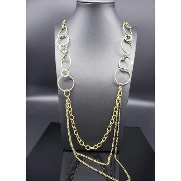 Smooth and shimmery textured hoops give way to layers of mismatched brass chains for a classic look. Features an adjustable clasp closure. Sold as one individual necklace. Includes one pair of matching earrings.  P2IN-BSXX-179XX