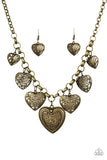 Swirling with mismatched filigree details, ornate brass heart frames swing from the bottom of a brass chain below the collar for a vintage look. Features an adjustable clasp closure. Sold as one individual necklace. Includes one pair of matching earrings.  P2WH-BRXX-157XX