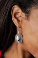 Earring: "Rebel Highness" (P5RE-SVXX-266OY)  An oversized hematite gem is pressed into a round silver frame encrusted in stacked rings of smoky rhinestones for a blinding finish. Earring attaches to a standard fishhook fitting. Sold as one pair of earrings.