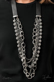 Attached to two strips of black leather, strands of bedazzled white rhinestone encrusted silver beads drape between an exaggerated display of mismatched silver and gunmetal chains down the chest. With its edgy sparkle, grunge meets glamour in this heart-stopping statement-maker. Features an adjustable clasp closure. Sold as one individual necklace. Includes one pair of matching earrings.  Named after 2020 Rock the Runway winner, Arlingto L.  Z2009