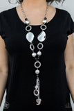 BLOCKBUSTER  Long chain of black crystalized beads, curved plates of silver with a pearly finish, and chunky silver rings lead down to a tassel of chains and charms, including a crescent moon and a heart. Sold as one individual necklace. Includes one pair of matching earrings.  P2RE-BKSV-019XX