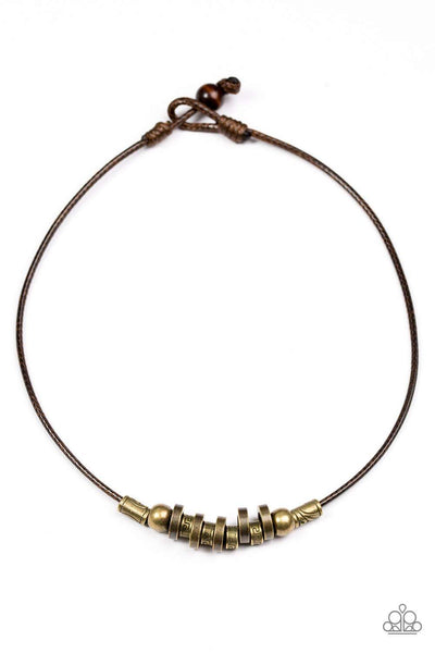 Stamped in tribal inspired patterns, antiqued brass accents and mismatched brass beads slide along a brown cord, creating an urban look below the collar. Features a button loop closure. Sold as one individual necklace. P2UR-BRXX-023XX