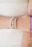 A skinny strip of pink leather is encrusted in sections of glittery white rhinestones and flat gold, gunmetal, and silver studs. The elongated band double wraps around the wrist for a fierce one-of-a-kind look. Features an adjustable snap closure. Sold as one individual bracelet.  P9DI-URPK-037XX