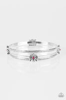 Embossed in tribal inspired patterns, two dainty silver bangles join a glistening silver bangle dotted in ornate silver frames. Glittery pink rhinestones dot the centers of the frilly frame, adding a refined sparkle to the layered palette. Sold as one set of three bracelets.  P9RE-PKXX-103XX