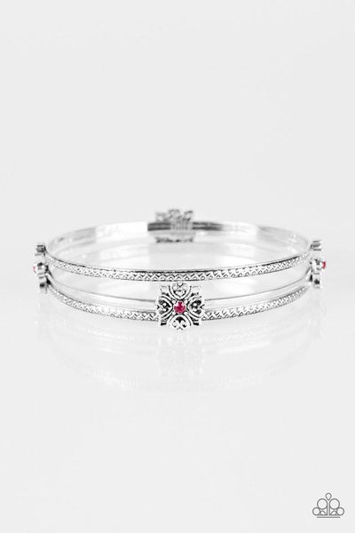 Embossed in tribal inspired patterns, two dainty silver bangles join a glistening silver bangle dotted in ornate silver frames. Glittery pink rhinestones dot the centers of the frilly frame, adding a refined sparkle to the layered palette. Sold as one set of three bracelets.  P9RE-PKXX-103XX