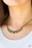 Featuring regal marquise style shapes, shimmery brass frames join below the collar. The sparkling pendant features mismatched aurum rhinestone accents for a refined finish. Features an adjustable clasp closure. Sold as one individual necklace. Includes one pair of matching earrings.   P2RE-BRXX-112VU