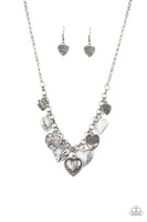 Featuring an array of floral patterns, a collection of silver hearts swing from the bottom of a shimmery silver chain. Alternating charms are brushed in a shiny white finish, creating a colorful fringe below the collar. Features an adjustable clasp closure. Sold as one individual necklace. Includes one pair of matching earrings. Get The Complete Look! Bracelet: "Garden Hearts - White" (Sold Separately)  P2WH-WTXX-233IV