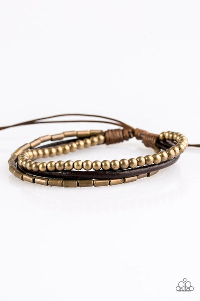 Mismatched strands of brown leather cording layer across the wrist. Featuring round and cylindrical shapes, antiqued brass beads are threaded along two strands for a seasonal finish. Features an adjustable sliding knot closure. Sold as one individual bracelet.  P9UR-BRXX-022XX