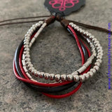 Mismatched strands of red and brown leather cording layer across the wrist. Featuring round and cylindrical shapes, antiqued silver beads are threaded along two strands for a seasonal finish. Features an adjustable sliding knot closure. Sold as one individual bracelet.  P9UR-RDXX-084XX