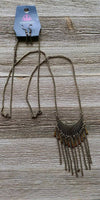 2018 October Fashion Fix Exclusive Radiating in linear textures, a glistening brass crescent swings from the bottom of a lengthened brass chain. Shimmery brass chains and flared brass beading swings from the bottom of the tribal inspired pendant, creating a flirtatious fringe. Features an adjustable clasp closure. Sold as one individual necklace. Includes one pair of matching earrings.  P2TR-BRXX-097XX