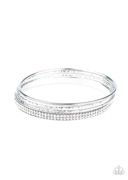 Pairs of smooth and hammered silver bangles join a white rhinestone encrusted bracelet around the wrist, creating an edgy stack of sparkle. Sold as one set of five bracelets.  P9RE-WTXX-406XX