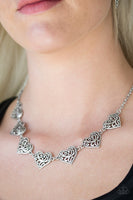 Featuring filigree-filled centers, glistening silver heart frames connect below the collar in a romantic fashion. Features an adjustable clasp closure. Sold as one individual necklace. Includes one pair of matching earrings.   P2WH-SVXX-224VH