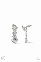 A white rhinestone encrusted silver heart attaches to a double-sided post, designed to fasten behind the ear. Stacked in gradually increasing white rhinestone encrusted heart frames, the glittery double-sided post peeks out beneath the ear for a charming look. Earring attaches to a standard post fitting. Sold as one pair of double-sided post earrings.  P5PO-WTXX-217XX