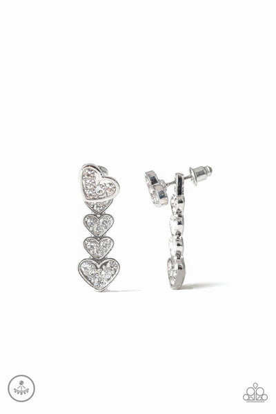 A white rhinestone encrusted silver heart attaches to a double-sided post, designed to fasten behind the ear. Stacked in gradually increasing white rhinestone encrusted heart frames, the glittery double-sided post peeks out beneath the ear for a charming look. Earring attaches to a standard post fitting. Sold as one pair of double-sided post earrings.  P5PO-WTXX-217XX