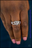 Encrusted in glittery pink rhinestones, silver ribbons crisscross across the finger, creating a dainty band. A glistening silver heart adorns the center of the band for a romantic finish. Features a dainty stretchy band for a flexible fit.  P4RE-PKXX-118XX