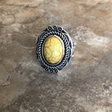 A sunny yellow stone is pressed into an antiqued silver frame radiating with floral detail for a seasonal look. Features a stretchy band for a flexible fit. Sold as one individual ring.  P4SE-YWXX-060XX