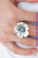 A bright blue bead is pressed into the center of a blooming silver flower radiating with antiqued details for a whimsical look. Features a stretchy band for a flexible fit. Sold as one individual ring.  P4WH-BLXX-146XX