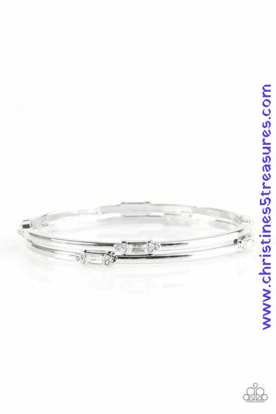 Featuring elegant round and emerald style cuts, glittery white rhinestones are pressed into two shimmery silver bangles for a refined look. Sold as one set of two bracelets.  P9RE-WTXX-197XX