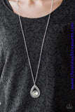 An oversized white rhinestone is nestled inside the bottom of a glistening silver teardrop radiating with studded textures. The dramatic pendant swings from the bottom of a lengthened silver chain for a regal look. Features an adjustable clasp closure. Sold as one individual necklace. Includes one pair of matching earrings.  P2RE-WTXX-350XX