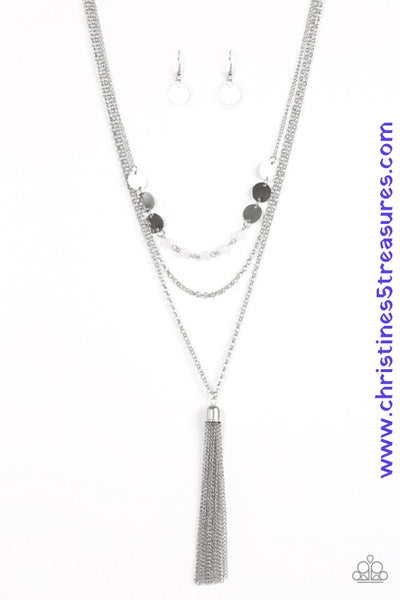 Three shimmery silver chains cascade down the chest. Glistening silver discs link with white crystal-like beading across the bottom of the uppermost chain, while a shiny silver chain tassel swings from the bottom of the lowermost chain for a flirty finish. Features an adjustable clasp closure. Sold as one individual necklace. Includes one pair of matching earrings.  P2RE-WTXX-267XX