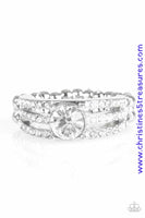 Encrusted in dainty white rhinestones, glistening silver bars layer across the finger, coalescing into a gorgeous band. A glittery white rhinestone is pressed into the center of the bands, creating a refined centerpiece. Features a dainty stretchy band for a flexible fit. Sold as one individual ring.  P4RE-WTXX-238XX