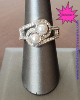 2020 March Fashion Fix Exclusive Glittery white rhinestone encrusted bands swirl around a pair of silver pearls for a refined look. Features a dainty stretchy band for a flexible fit. Sold as one individual ring. P4RE-SVXX-137XX