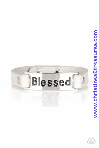Stamped in the word, "Blessed", a shiny silver plate is studded in place along a dainty gray leather band for a whimsical look. Features an adjustable snap closure. Sold as one individual bracelet.  P9WD-SVXX-156XX