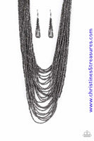 Brushed in an icy metallic shimmer, countless strands of gunmetal seed beads drape across the chest in a bold fashion. Featuring a collision of shapes and shimmer, the glittery strands connect to two large gunmetal accents for a flashy finish. Features an adjustable clasp closure. Sold as one individual necklace. Includes one pair of matching earrings.  P2SE-BKXX-219XX
