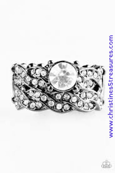 Encrusted in glassy white rhinestones, glistening ribbons of gunmetal weave across the finger, coalescing into a braided band. A dramatic white rhinestone is pressed into the band, creating a regal centerpiece. Features a stretchy band for a flexible fit. Sold as one individual ring. P4RE-BKXX-140XX