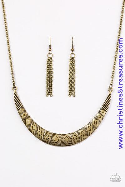 Stamped in tribal inspired patterns, a brass crescent-shaped plate swings from the bottom of a shimmery brass chain, creating a bold pendant below the collar. Features an adjustable clasp closure. Sold as one individual necklace. Includes one pair of matching earrings.  P2TR-BRXX-057XX
